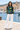 Coastal harbor with white linen trousers, front view