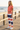 Coral tee and striped joggers on a beach boardwalk