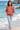 Dark-haired model in a barefoot shoreline look with jeans