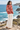 Dark-haired model showcasing the hoodie’s back at a coastal overlook