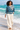 Female barefoot beach look with cream linen trousers
