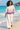 Female barefoot beach look with cream linen trousers