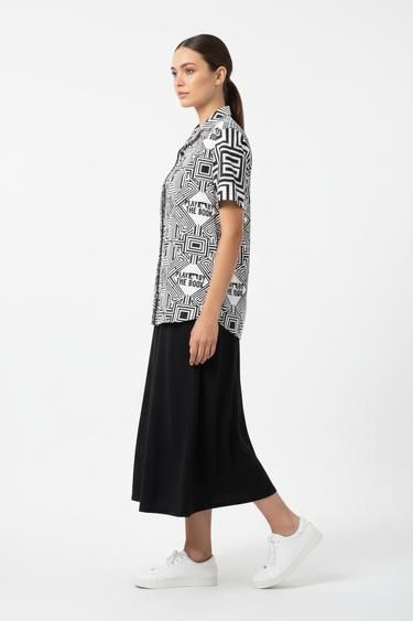 Female model in black midi skirt and white sneakers