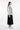 Female model in black midi skirt and white sneakers