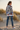 Female model showcasing the back of the sweatshirt with distressed jeans