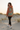 Female model showcasing the hoodie back with black leggings