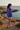 Female model showcasing the sweatshirt back with boardshorts
