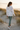 Female model showcasing the sweatshirt back with sage leggings