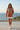 Female model styling the hoodie with a white pleated skirt