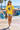 Female model wearing the daisy skeleton skate tee near a beach skatepark