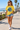 Female model wearing the daisy skeleton-wave tee on a beach boardwalk