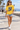 Female model wearing the daisy skull-skate tee on a beach boardwalk