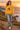 Female model wearing the gold sweatshirt on a coastal cliff path