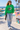 Female model wearing the Irish-green sweatshirt near a beach skatepark