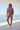 Female model wearing the matching Rose Mist set at a coastal villa