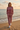 Female model wearing the matching rose sweatshirt and joggers on the beach