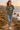 Female model wearing the military-green tee on a coastal cliff path