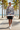 Female model wearing the newspaper-print sweatshirt with black boardshorts