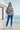 Female model wearing the newspaper-print sweatshirt with blue joggers
