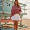 Female model wearing the sweatshirt with a white pleated skirt