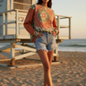 Female model wearing the sweatshirt with light-wash denim shorts