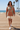 Female model wearing the terracotta spiral hoodie with cream boardshorts