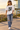 Female model wearing the white skull-skate tee near a lifeguard tower