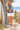Floral sweater styled with linen shorts beside a beach shack