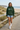 Forest hoodie with jean shorts on a beach boardwalk