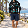 Geometric hoodie with navy boardshorts on a seaside promenade
