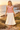 Golden-hour dunes look with an ivory pleated skirt