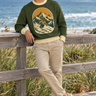 Green ski sweater on a coastal boardwalk