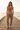 Head-to-toe editorial of the female model wearing the printed joggers and terracotta bodysuit