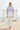 Full-length female model wearing the pastel all-over-print recycled hoodie beside a beach cabana