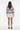 Full-length female model wearing the pastel striped all-over-print sweatshirt with white tailored shorts on a white background, back view
