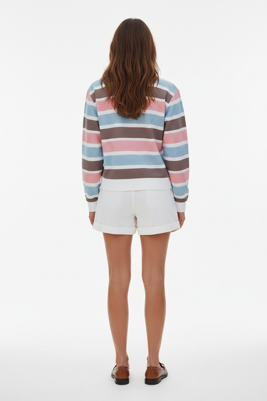 Full-length female model wearing the pastel striped all-over-print sweatshirt with white tailored shorts on a white background, back view