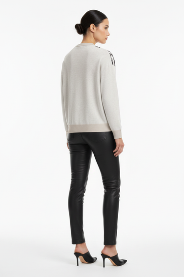 Back view of sweater styled with black leather pants