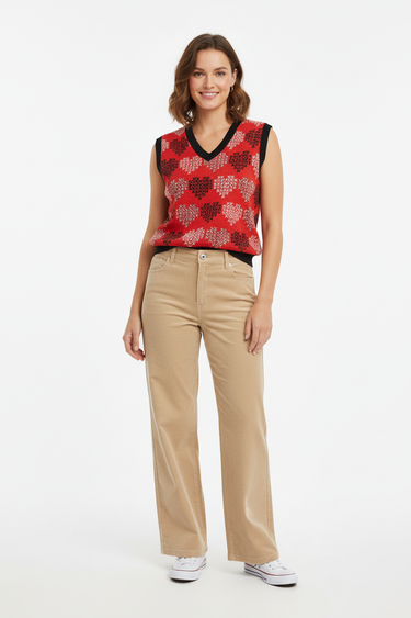 Bold hearts vest with beige corduroy pants for relaxed casual style