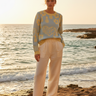 Look 1 – Wide-leg cream trousers, rocky shoreline
