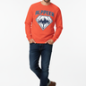 Male model in burnt orange crewneck with dark denim jeans