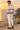 Male model in sweatshirt and cream linen trousers, coastal back view