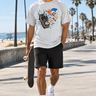Male model wearing the ash skeleton skate tee on a beach boardwalk