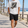Male model wearing the ash skull-skate tee on a beach boardwalk