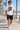 Male model wearing the ash skull-skate tee on a beach boardwalk