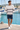 Male model wearing the hoodie with navy shorts at the marina