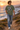 Male model wearing the military-green tee on a coastal cliff path