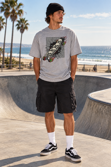 Male model wearing the sport-grey tee beside a beachfront skate bowl