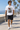 Male model wearing the white vampire skate tee on a beach boardwalk
