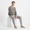 Model in sweater with gray joggers and slip-ons