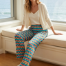 Model sitting comfortably in palm-print pajama pants
